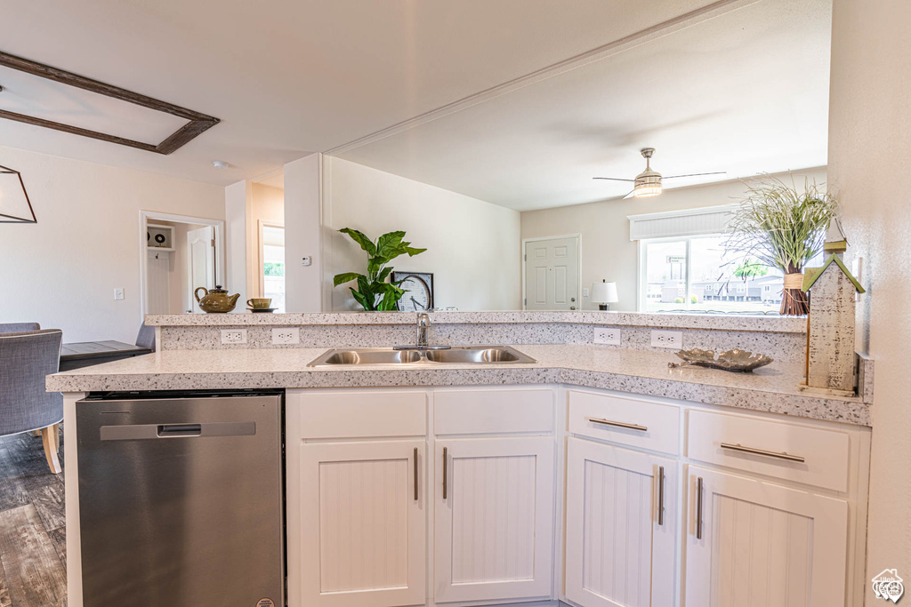 Kitchen with sink, white cabinetry, stainless steel dishwasher, ceiling fan, and kitchen peninsula