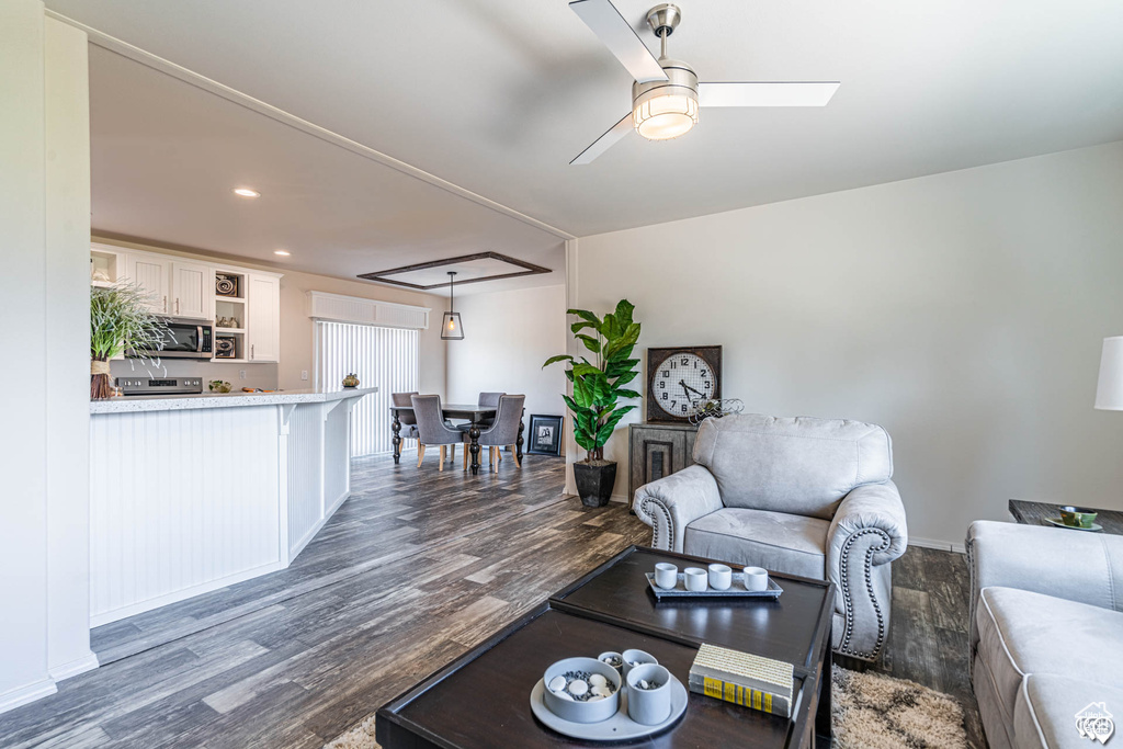 Living room featuring ceiling fan and dark hardwood / wood-style flooring