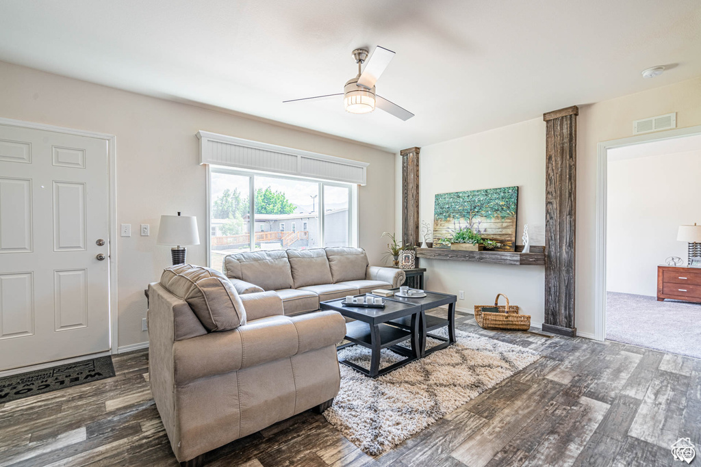 Living room with ceiling fan and dark hardwood / wood-style floors