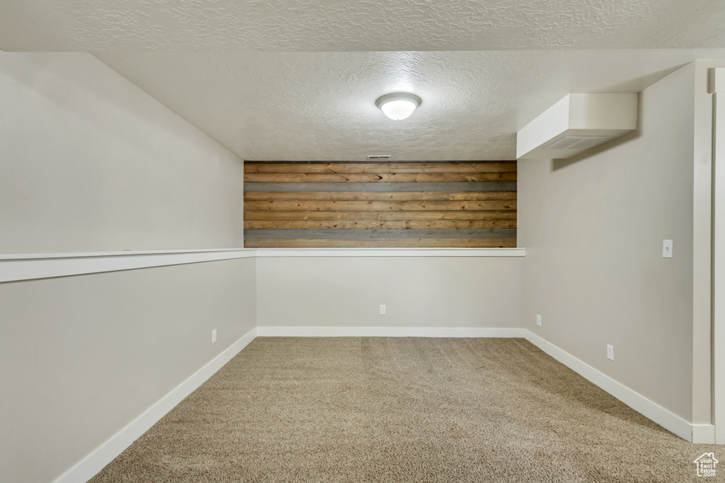 Carpeted empty room featuring a textured ceiling