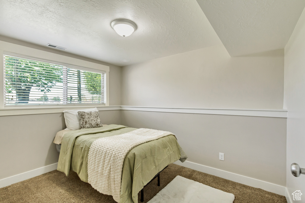 Bedroom featuring a textured ceiling and carpet