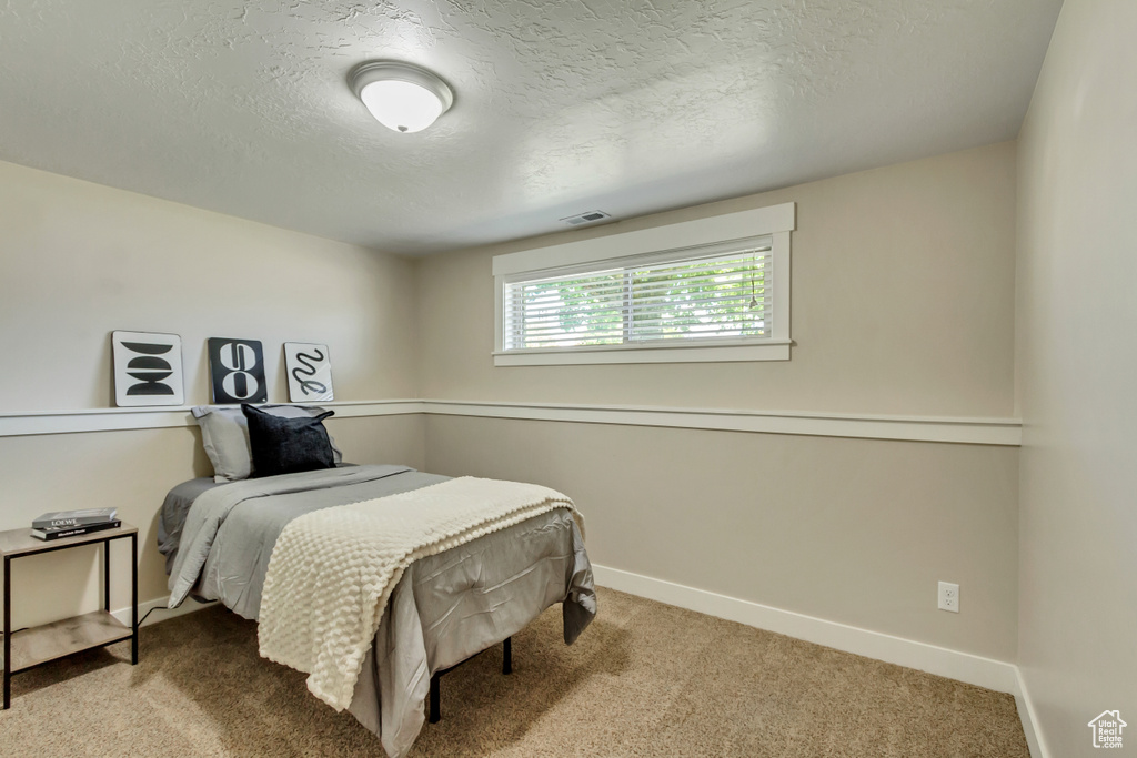 Carpeted bedroom with a textured ceiling