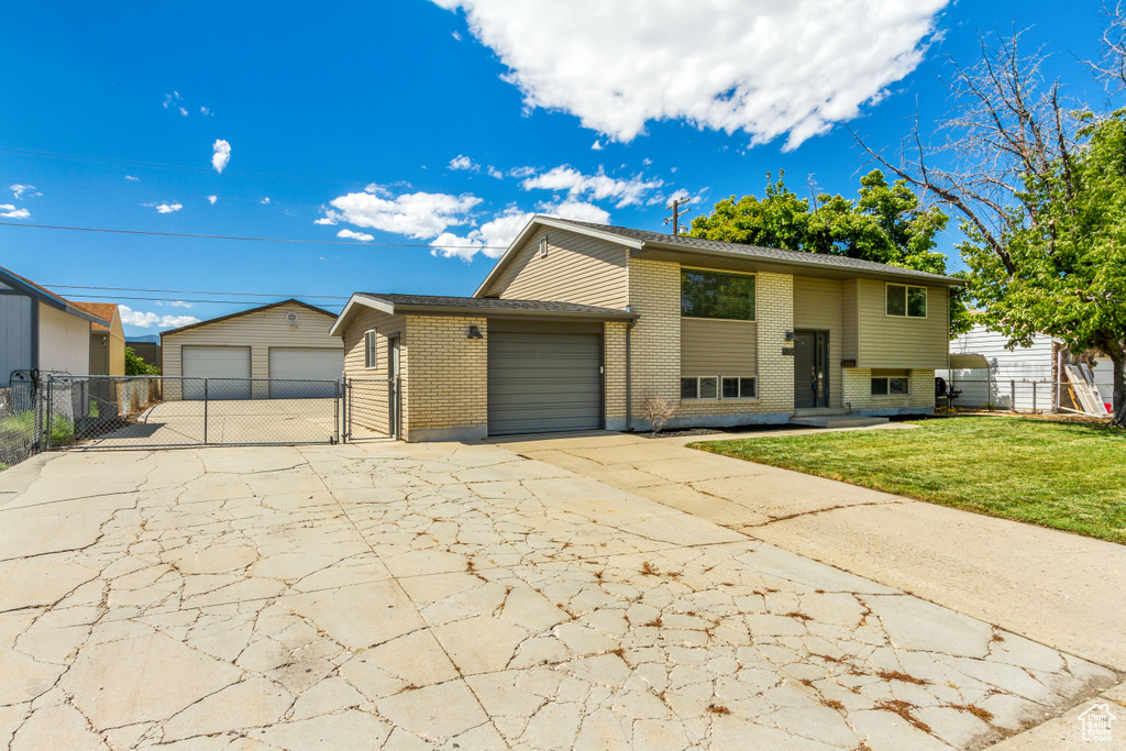 Raised ranch featuring a garage and a front yard