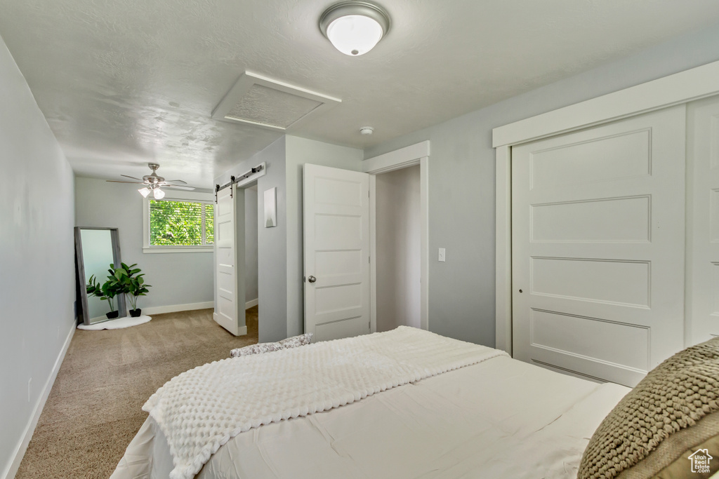 Carpeted bedroom featuring a barn door