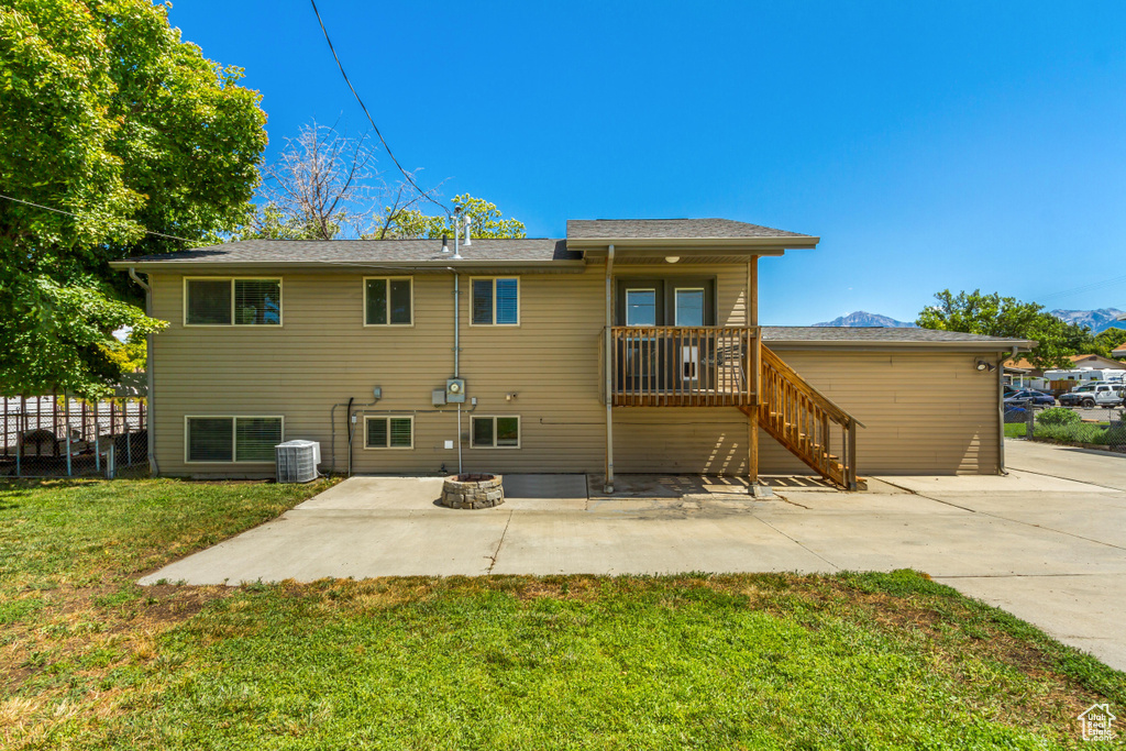 Rear view of property with a patio, a yard, and central AC unit