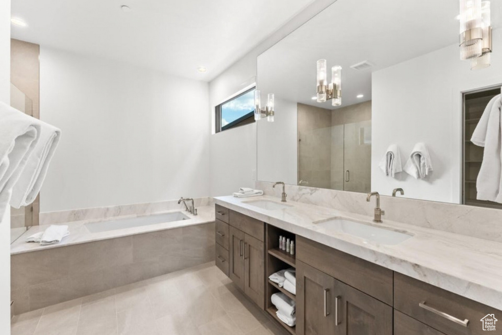 Bathroom featuring dual vanity, shower with separate bathtub, and tile patterned flooring