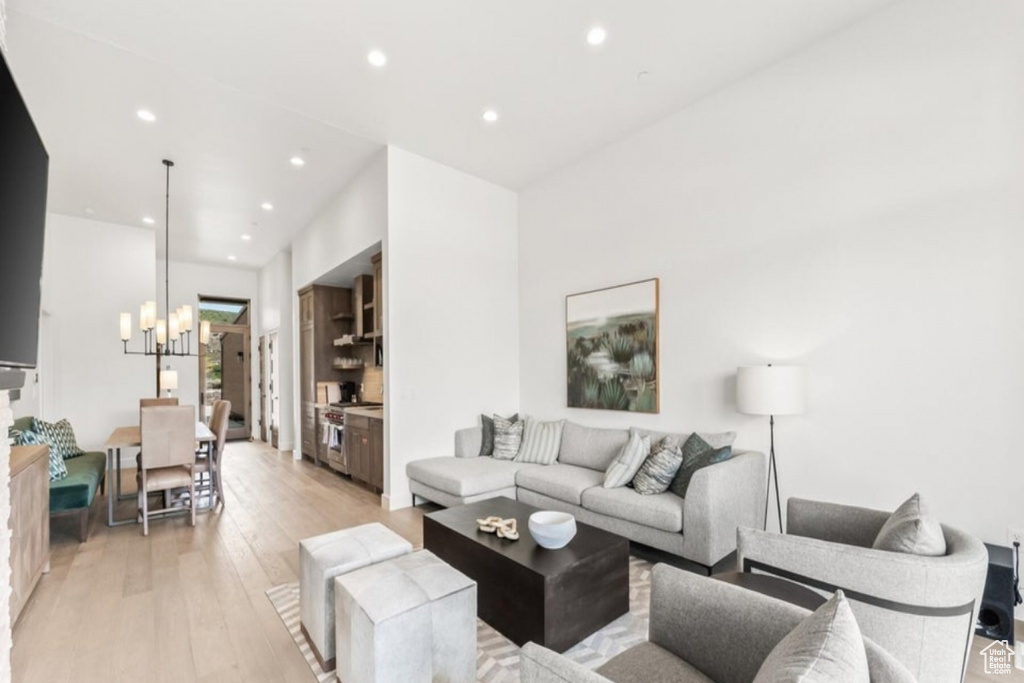 Living room with an inviting chandelier and light hardwood / wood-style floors