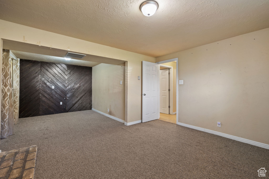 Basement featuring carpet floors and a textured ceiling