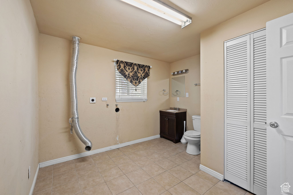 Bathroom featuring tile patterned flooring, vanity, and toilet