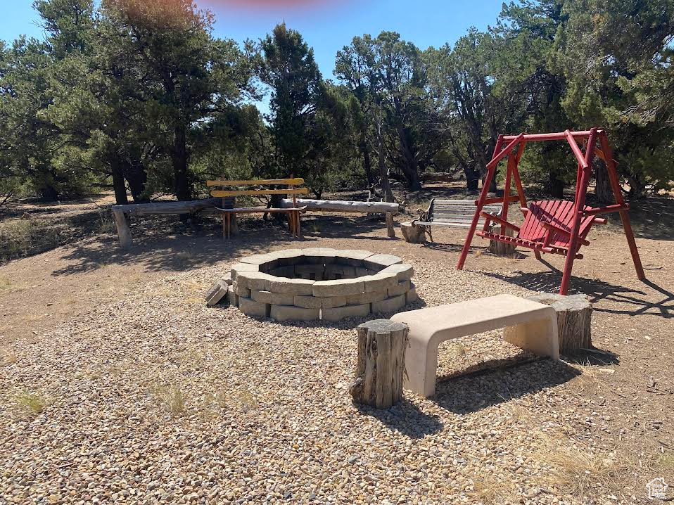 View of jungle gym with an outdoor fire pit