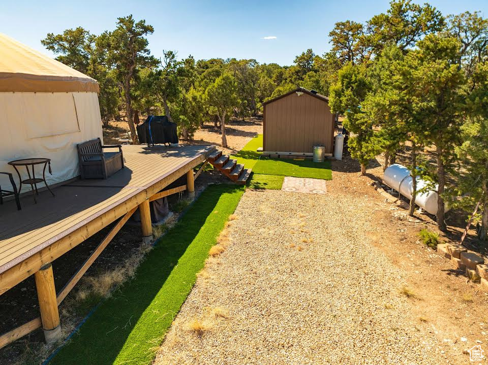 View of yard featuring a deck and a shed