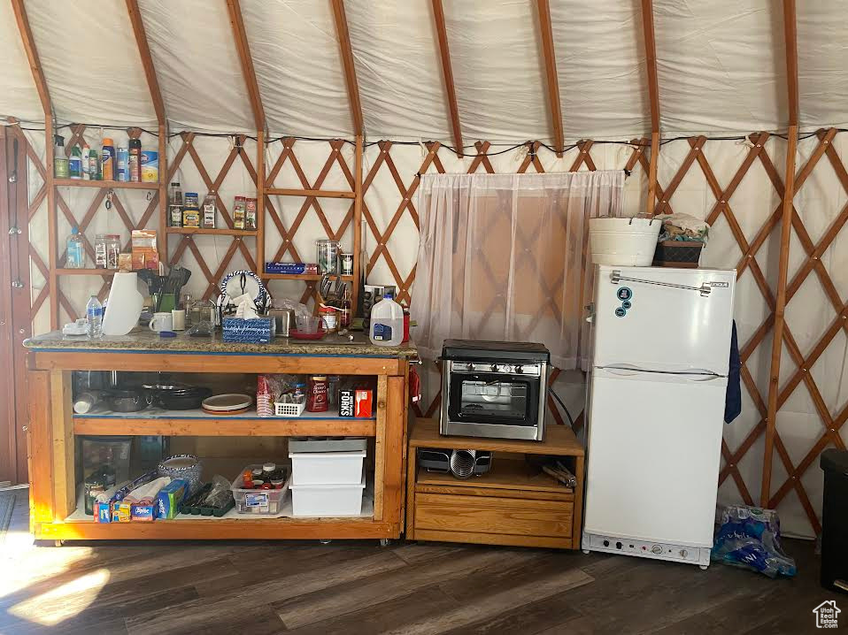 Kitchen with dark wood-type flooring and white fridge