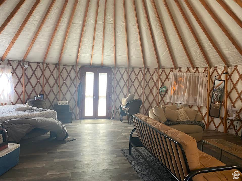 Bedroom featuring vaulted ceiling, hardwood / wood-style flooring, and french doors