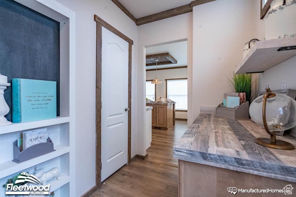 Interior space with hardwood / wood-style floors, ornamental molding, and a tray ceiling