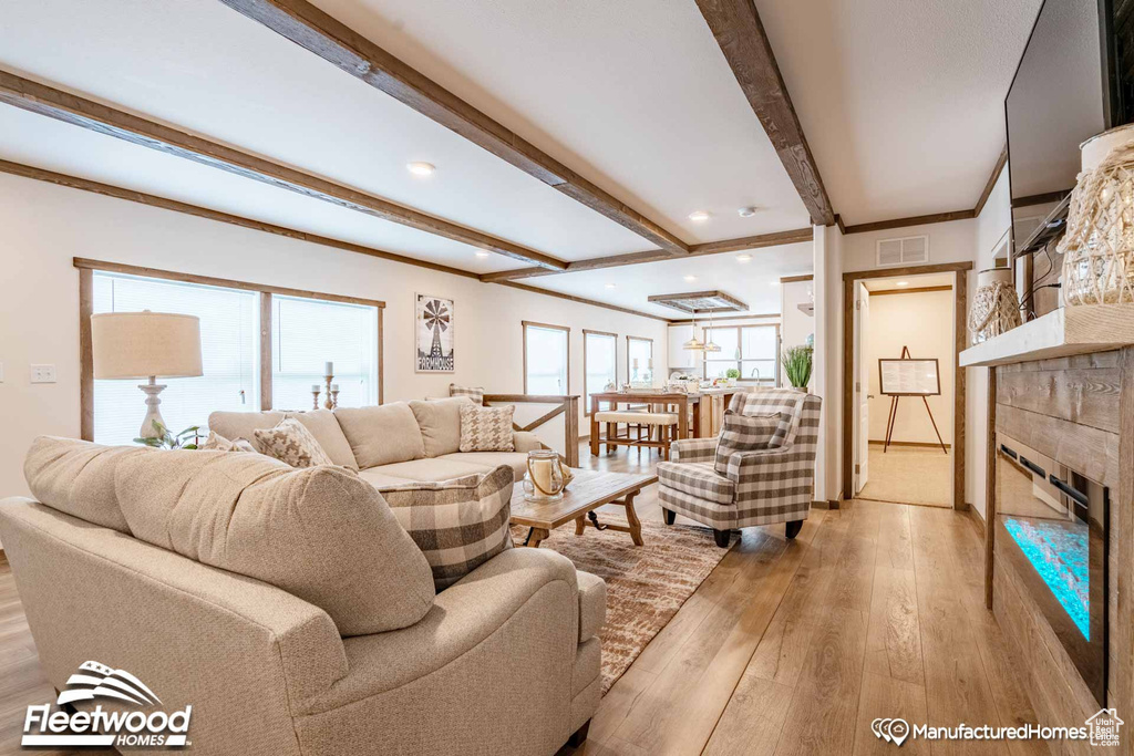 Living room with beam ceiling, light hardwood / wood-style flooring, and a fireplace