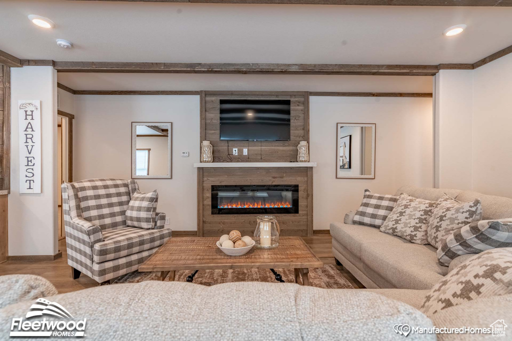 Living room featuring a fireplace, crown molding, and hardwood / wood-style floors