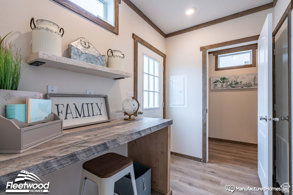 Interior space with a breakfast bar, ornamental molding, wooden counters, and wood-type flooring