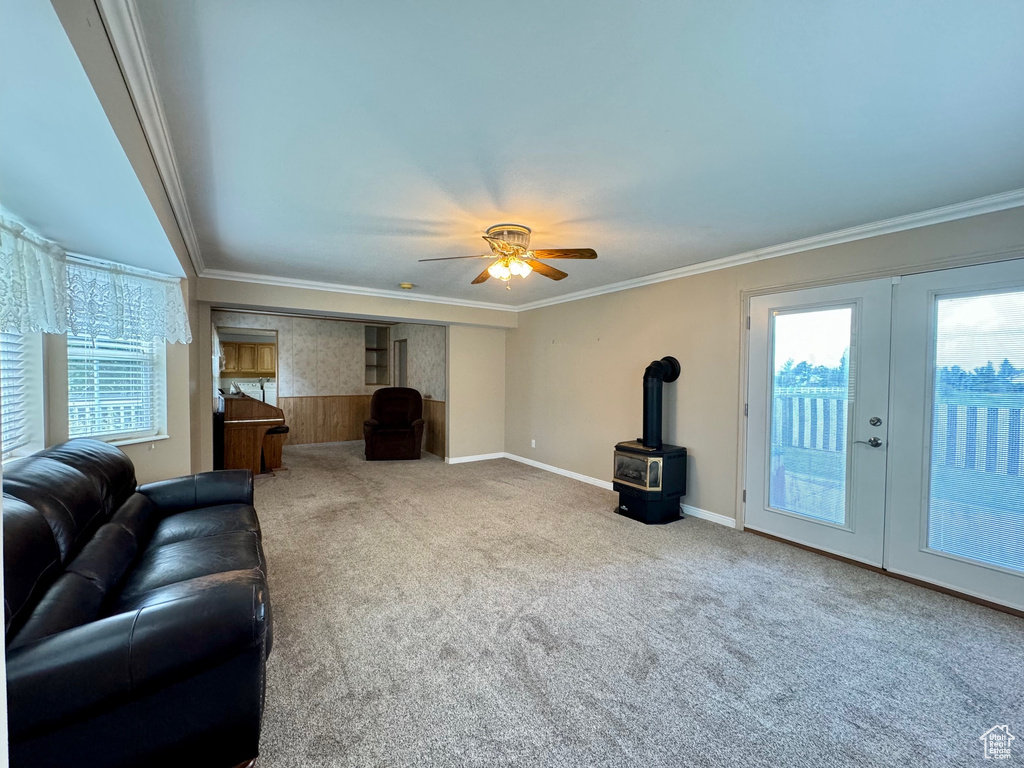 Living room featuring ceiling fan, carpet, ornamental molding, and french doors