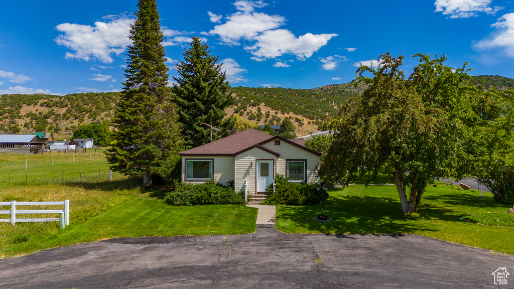 View of front facade featuring a mountain view and a front yard