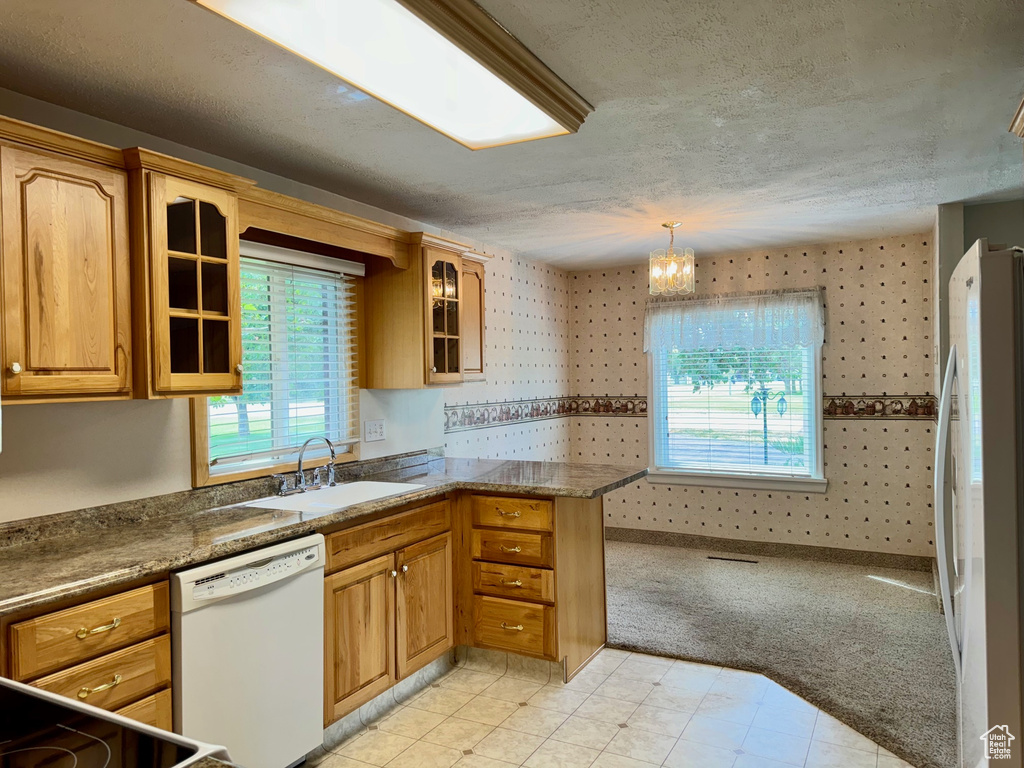 Kitchen with hanging light fixtures, sink, an inviting chandelier, light tile patterned flooring, and white appliances