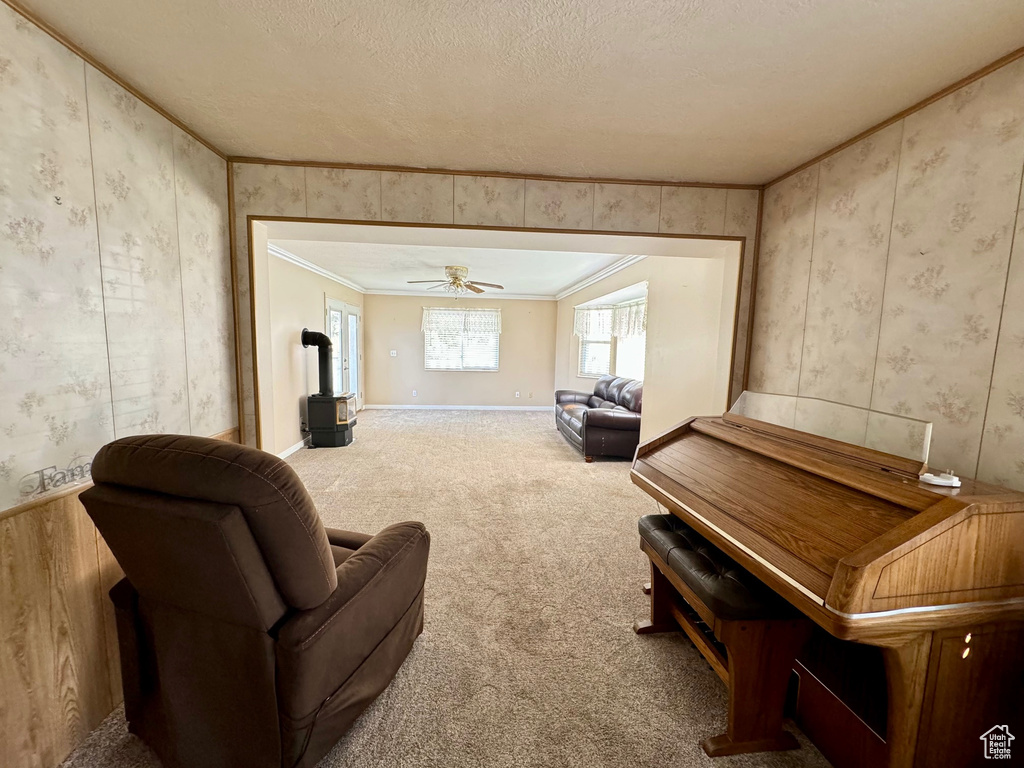 Sitting room with a textured ceiling, carpet flooring, ceiling fan, and ornamental molding