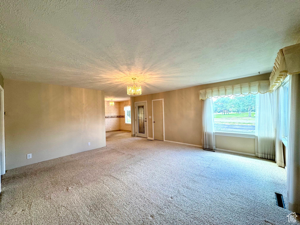 Interior space featuring light colored carpet and a textured ceiling