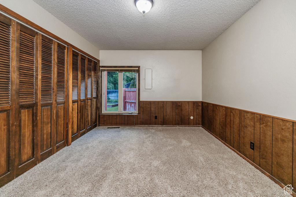 Carpeted spare room with a textured ceiling