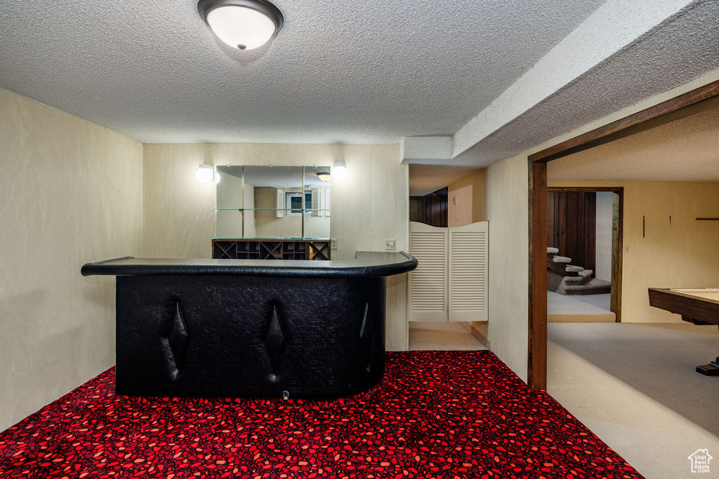 Interior space with a textured ceiling, light carpet, and billiards