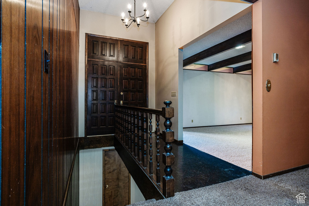 Entryway featuring a chandelier and carpet