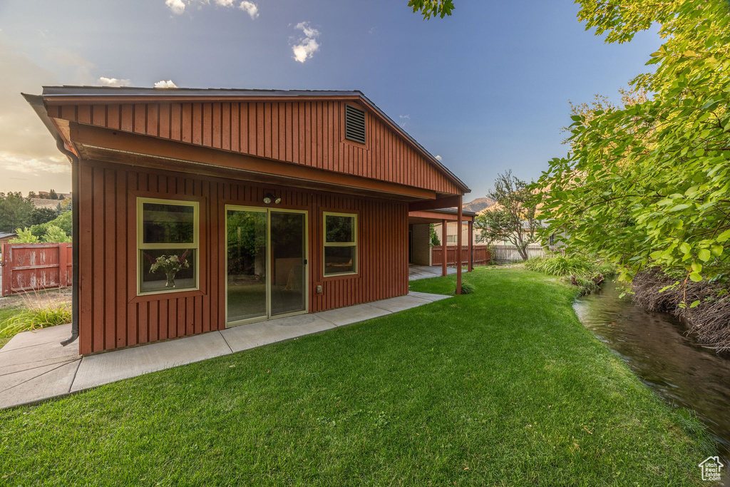 Rear view of property with a patio area and a yard