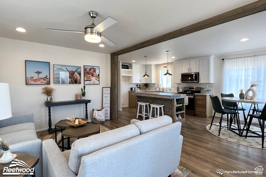 Living room featuring sink, ceiling fan, and dark hardwood / wood-style flooring