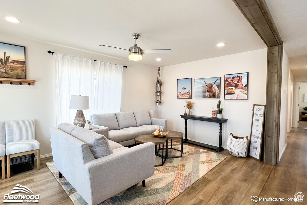 Living room with ceiling fan and light hardwood / wood-style floors