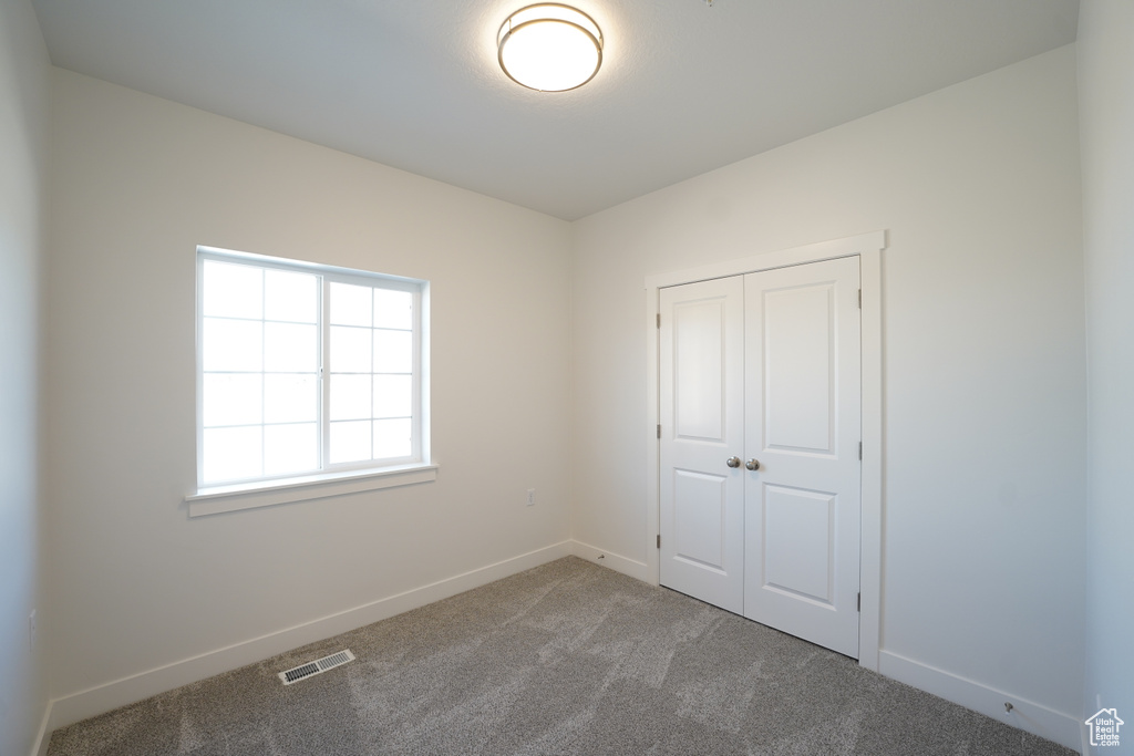 Unfurnished bedroom featuring carpet and a closet