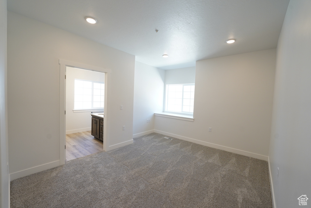 Carpeted empty room with a healthy amount of sunlight