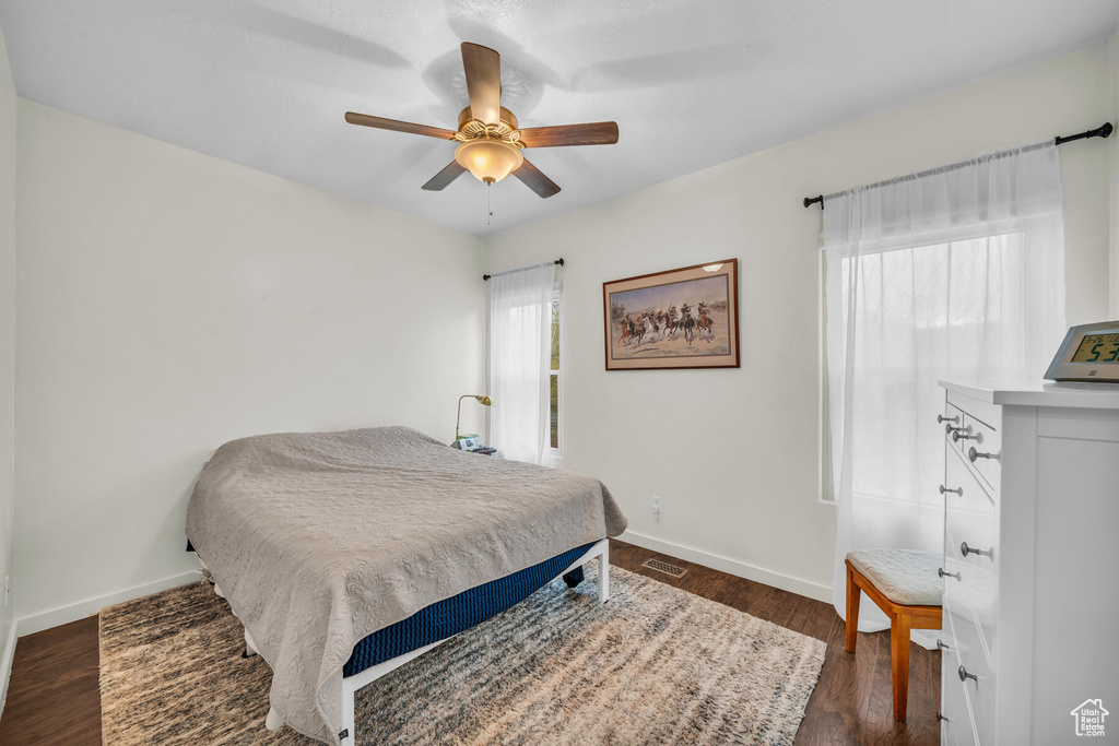 Bedroom with ceiling fan and dark hardwood / wood-style floors