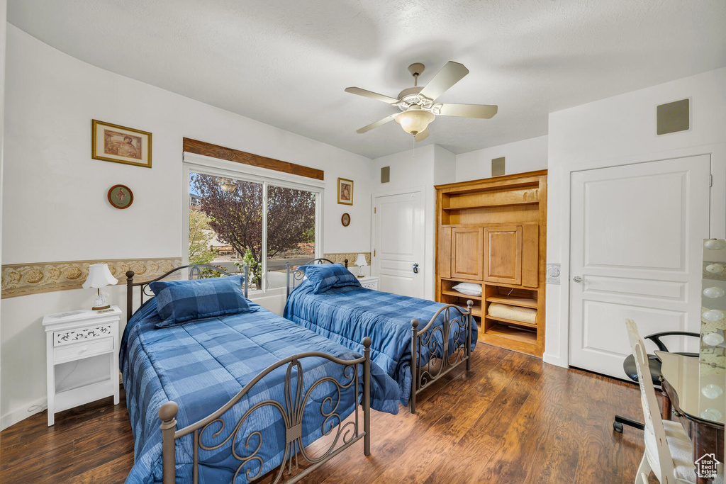 Bedroom featuring ceiling fan and dark wood-type flooring