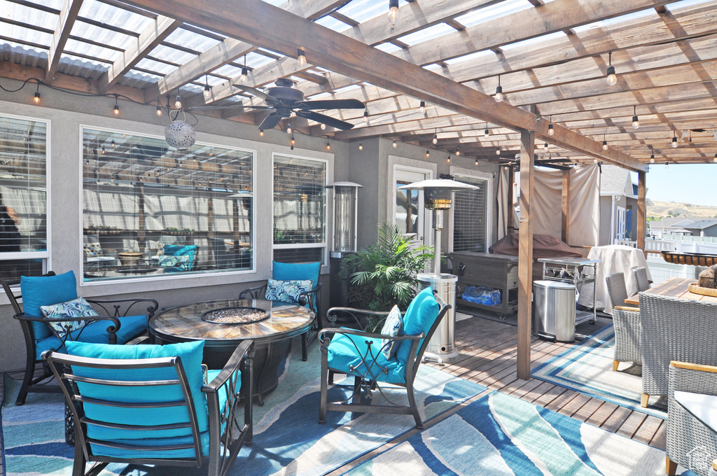 View of patio featuring a pergola, ceiling fan, and a fire pit