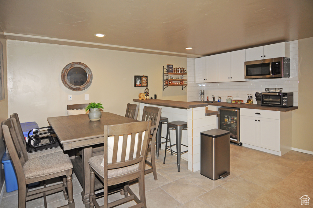 Tiled dining room with beverage cooler