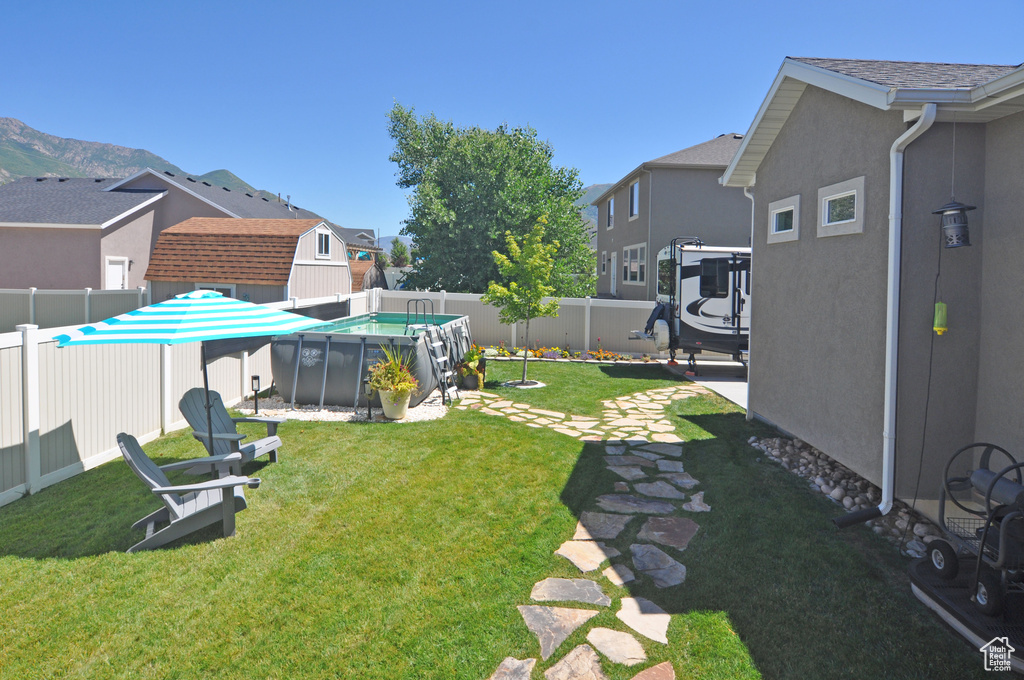 View of yard featuring a patio, a fenced in pool, and a shed