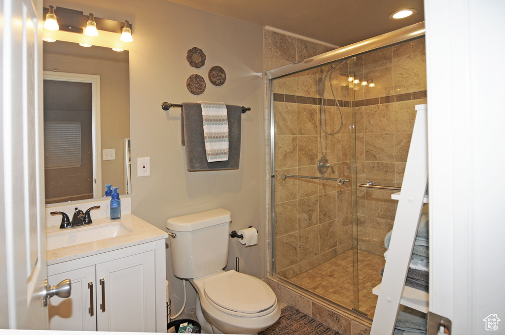 Bathroom with an enclosed shower, vanity, and toilet