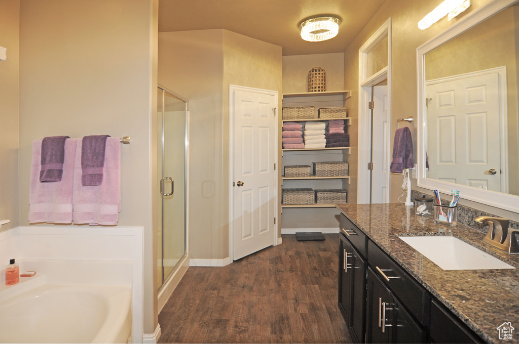 Bathroom featuring hardwood / wood-style flooring, independent shower and bath, and vanity