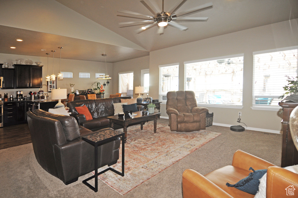 Living room featuring ceiling fan, vaulted ceiling, and light colored carpet