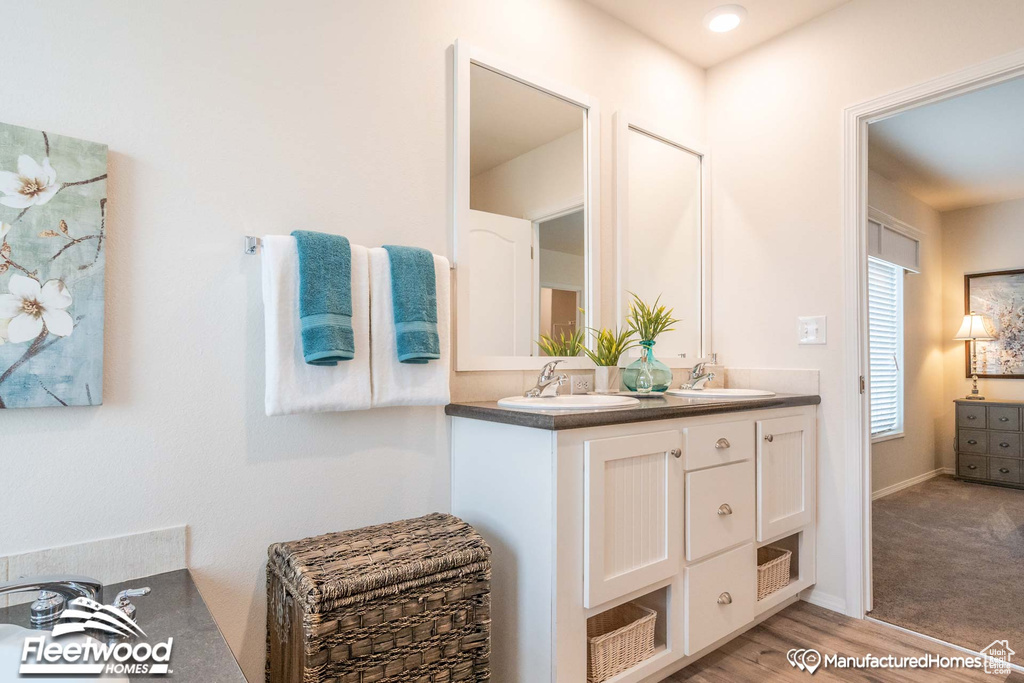 Bathroom featuring dual vanity and wood-type flooring