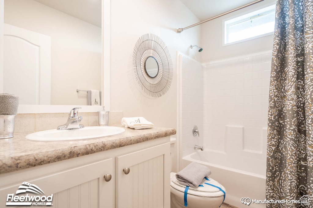 Full bathroom featuring vanity, shower / bathtub combination with curtain, and toilet