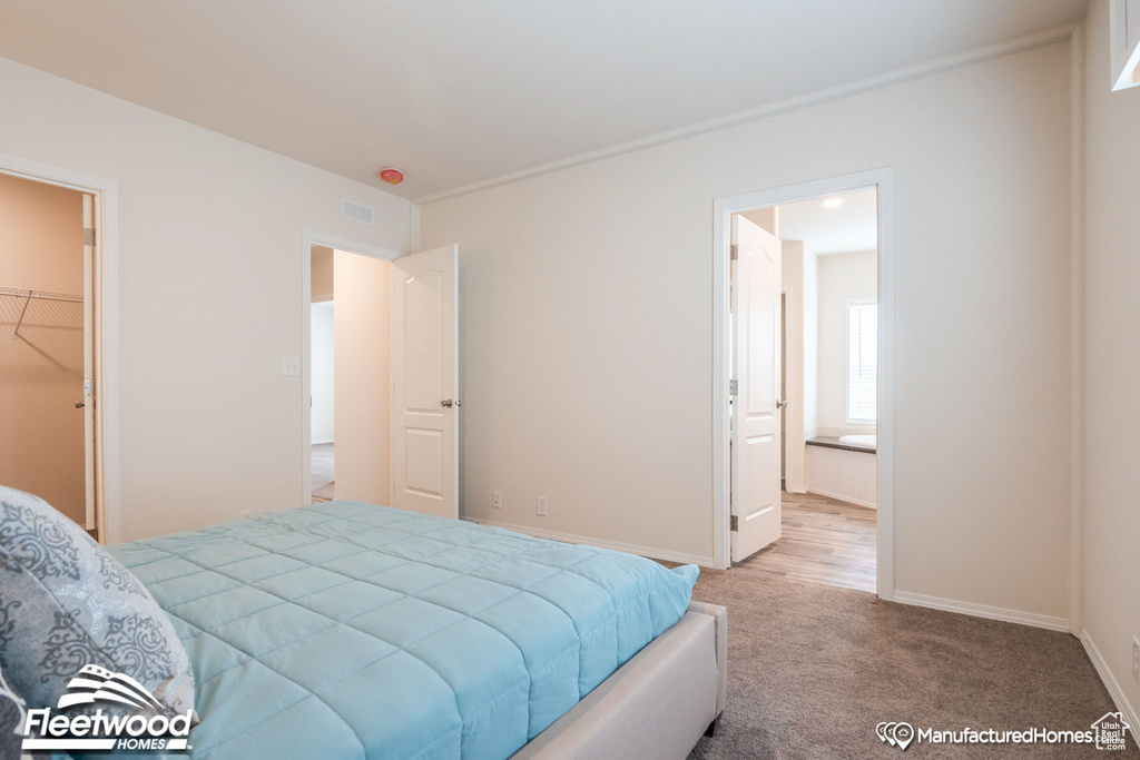 Carpeted bedroom with a closet, a spacious closet, and ensuite bathroom