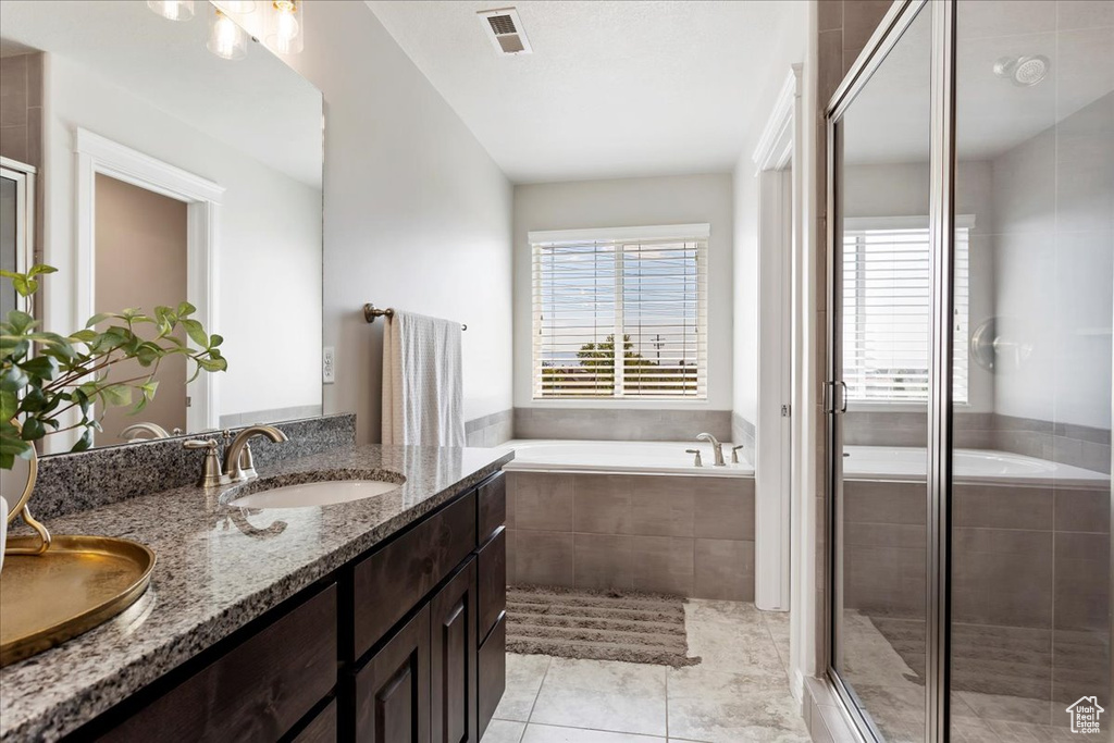 Bathroom featuring independent shower and bath, double vanity, and tile patterned flooring