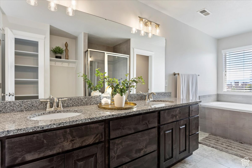 Bathroom with independent shower and bath, double vanity, and tile patterned flooring