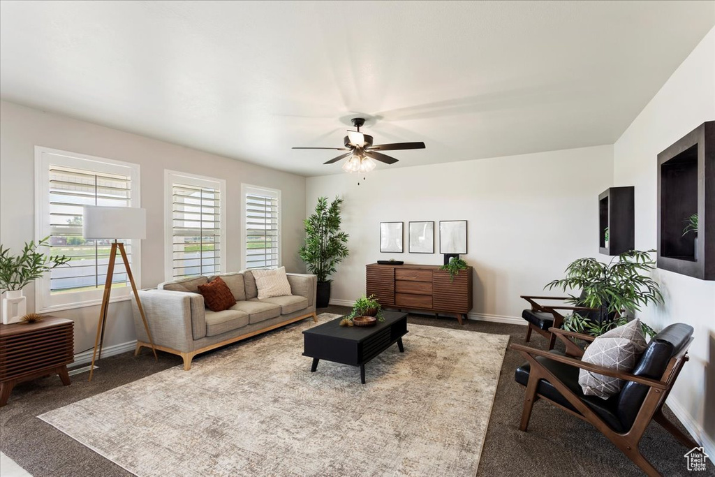 Living room with ceiling fan and light carpet