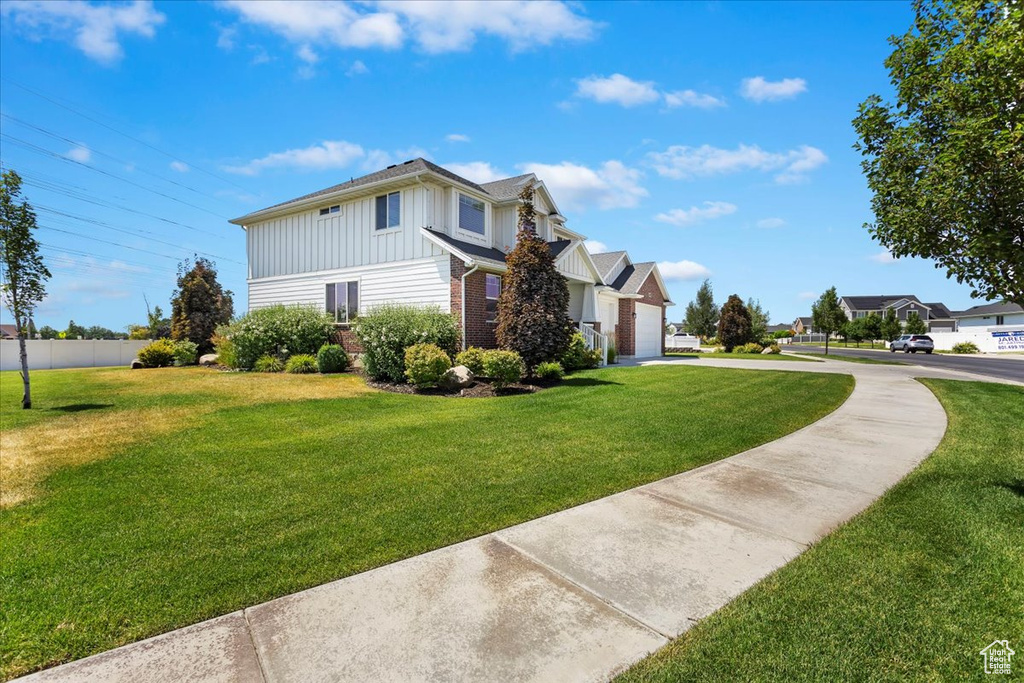 View of home's exterior featuring a lawn and a garage