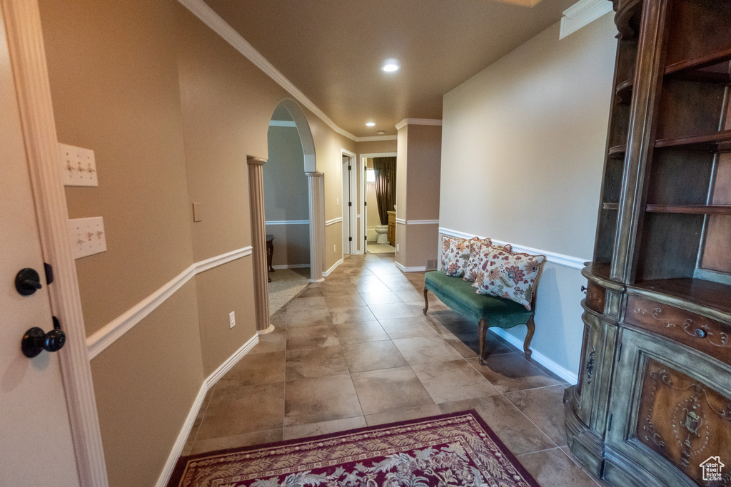 Corridor featuring crown molding and light tile patterned flooring